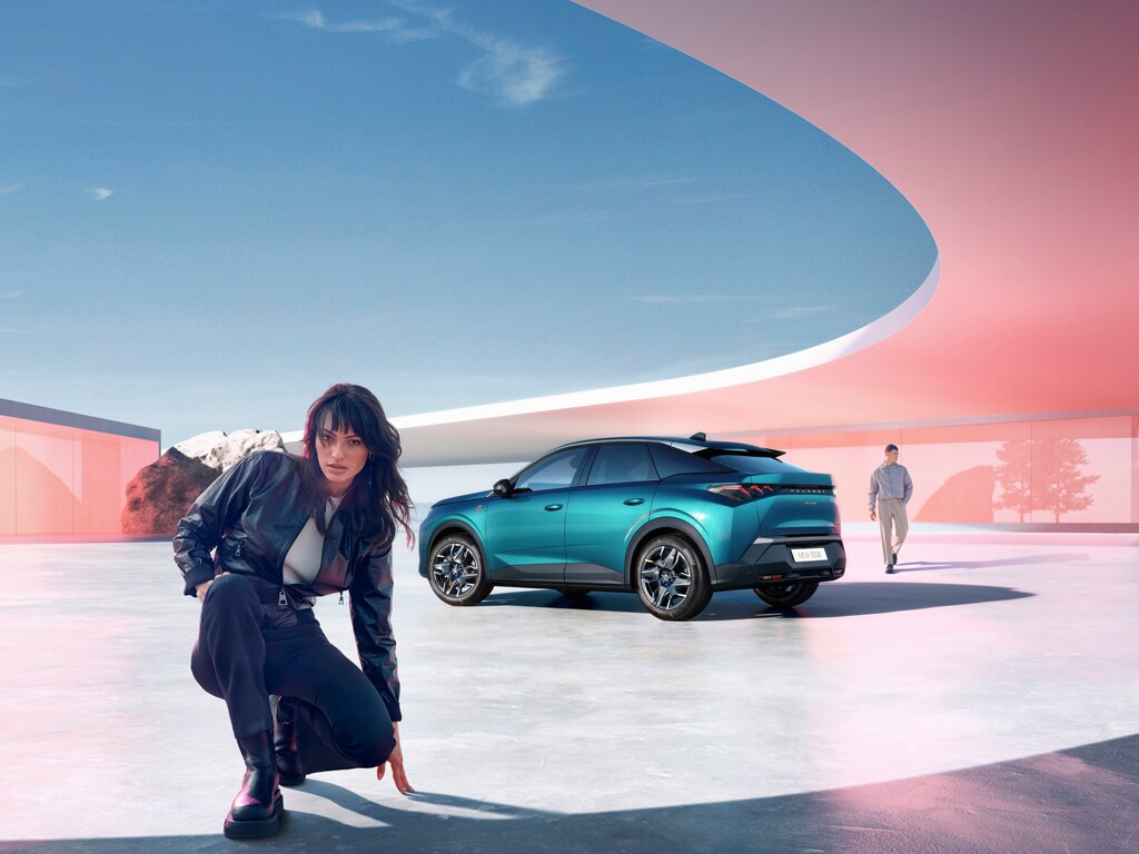 Woman kneeling next to new PEUGEOT 3008 hybrid with rear view